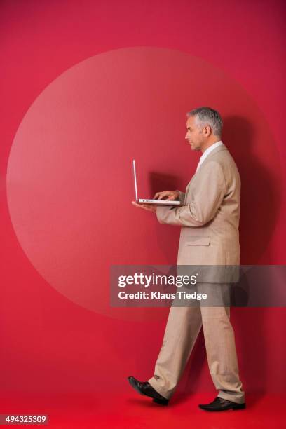 businessman walking with laptop - laptop colored background stock pictures, royalty-free photos & images