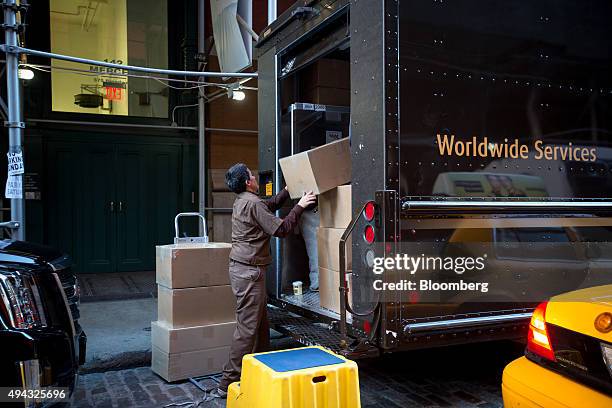 United Parcel Service Inc. Driver loads a truck with packages in the Soho neighborhood of New York, U.S., on Friday, Oct. 23, 2015. UPS is scheduled...
