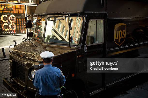 An New York Police Department traffic officer writes a parking ticket for a United Parcel Service Inc. Truck in New York, U.S., on Friday, Oct. 23,...