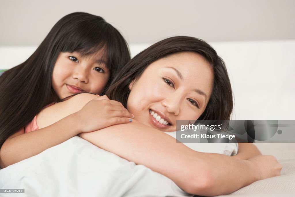 Mother and daughter laying on bed