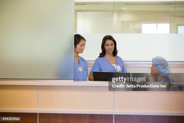 nurses talking in hospital - nurses station stock pictures, royalty-free photos & images