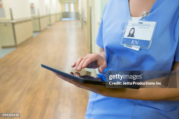 mixed race nurse using digital tablet - electronic medical record stock pictures, royalty-free photos & images