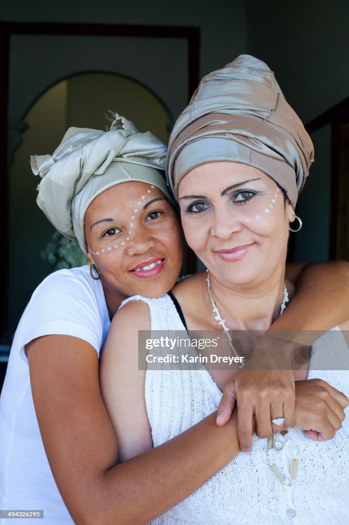 Mixed race women hugging