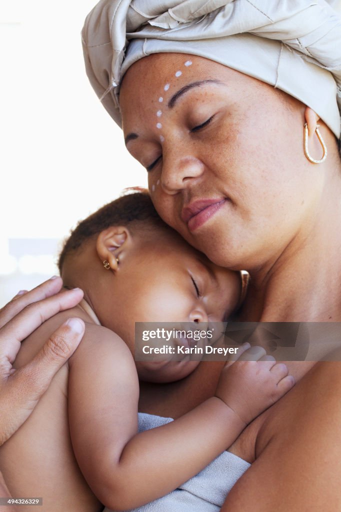 Mixed race mother cradling baby