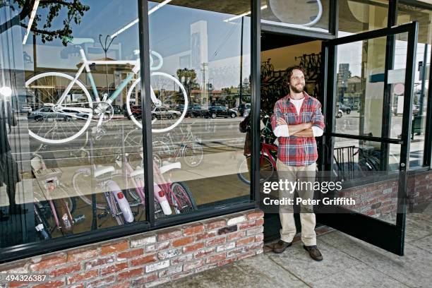 caucasian man smiling in bicycle shop - loja de bicicletas imagens e fotografias de stock