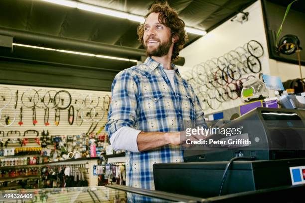 caucasian man working in bicycle shop - kassierer stock-fotos und bilder