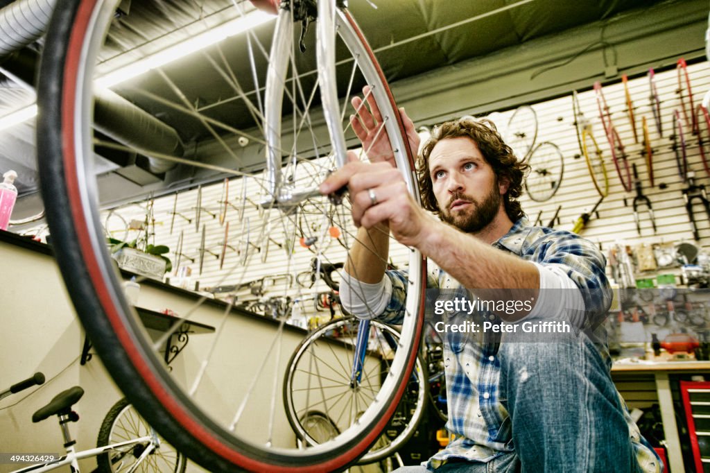 Caucasian man smiling in bicycle repair shop