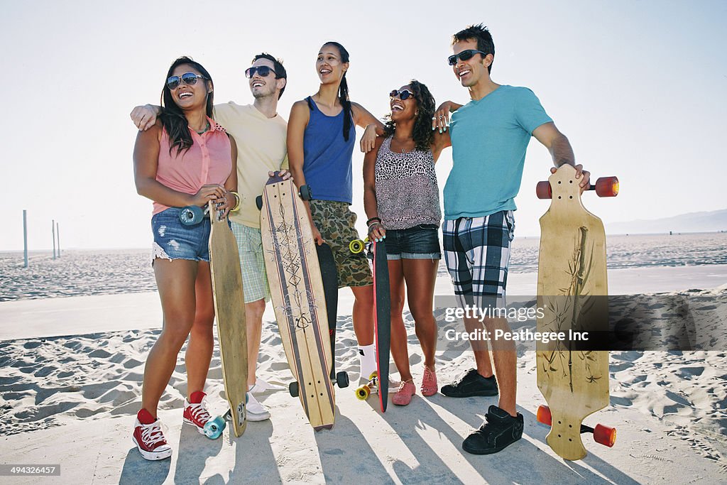 Friends holding longboards on beach