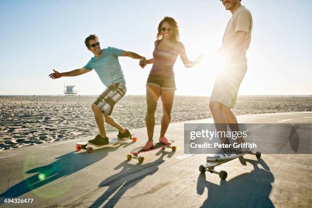 friends riding longboards on beach - longboard skating 個照片及圖片檔