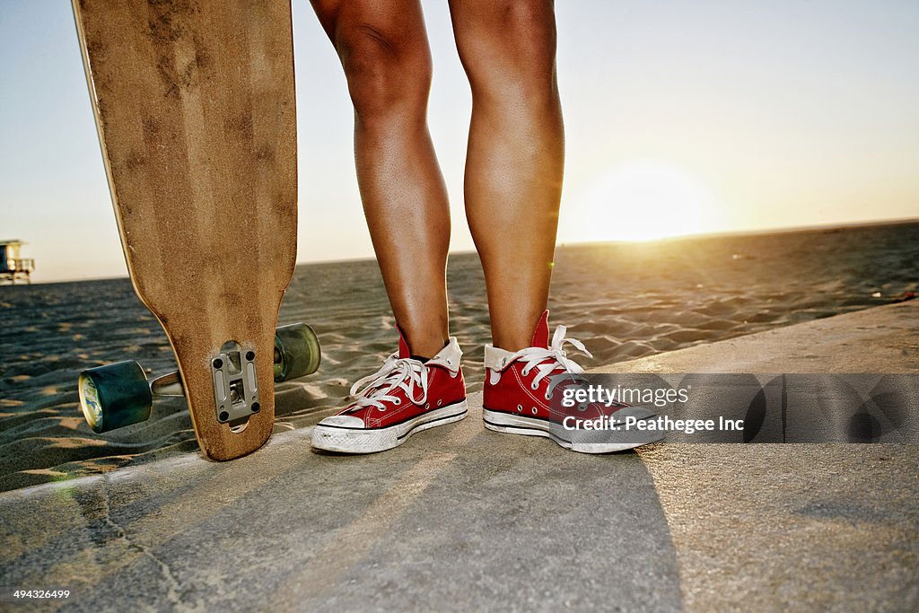 Woman holding longboards on beach