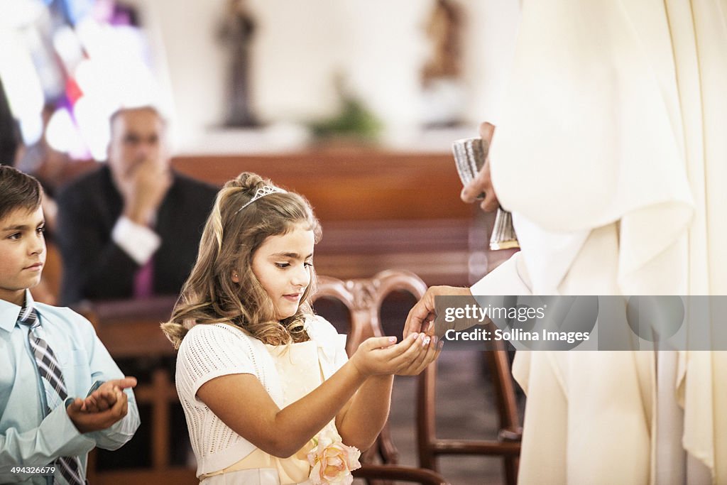 Girl taking her first communion at church