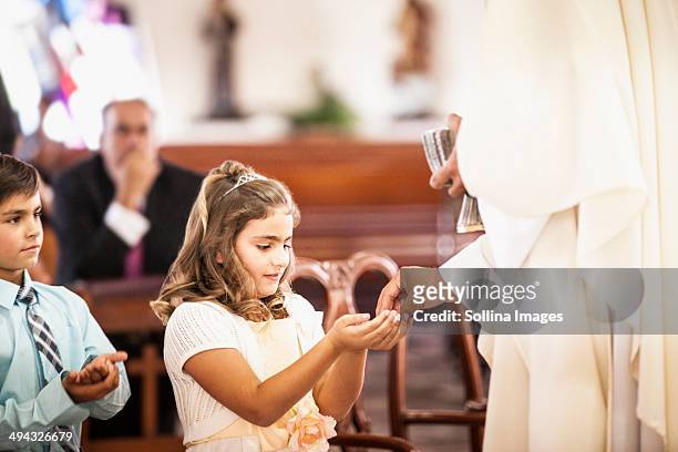 girl taking her first communion at church - comunion fotografías e imágenes de stock
