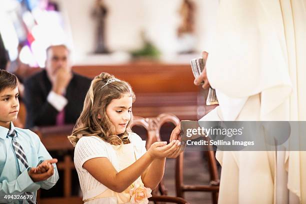 girl taking her first communion at church - comunhão imagens e fotografias de stock