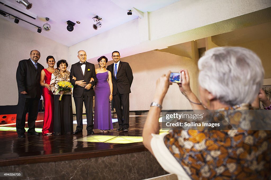 Hispanic family taking pictures at wedding reception