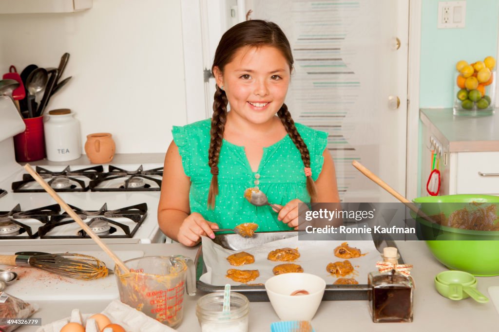 Mixed race girl baking in kitchen