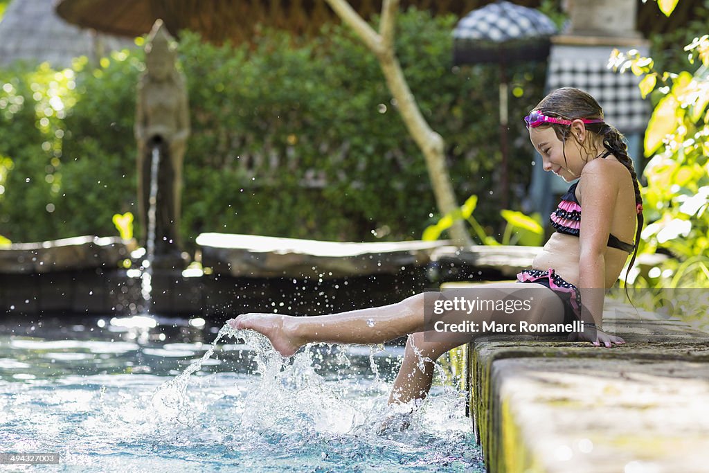 Caucasian girl splashing in swimming pool