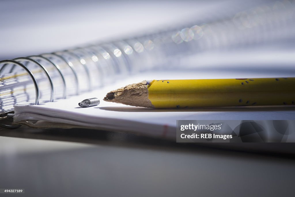 Close up of broken pencil on notebook