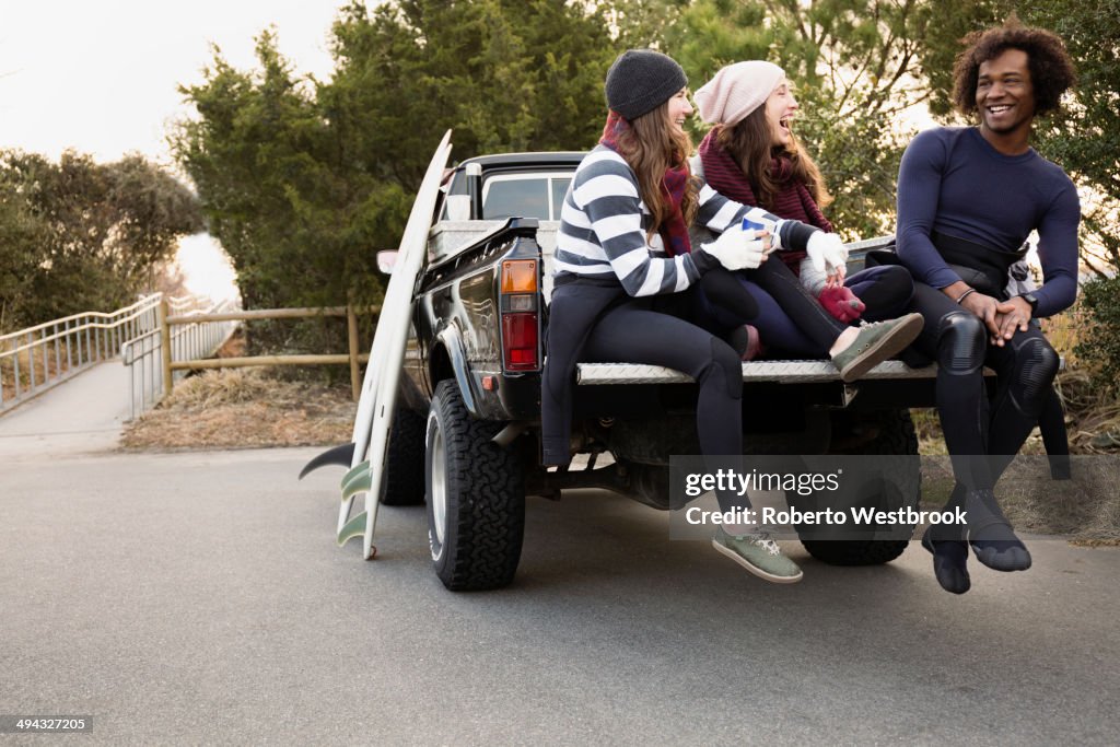 Friends having coffee together in truck bed