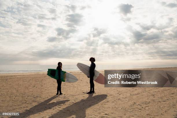 surfers carrying boards on beach - virginia beach va stock pictures, royalty-free photos & images