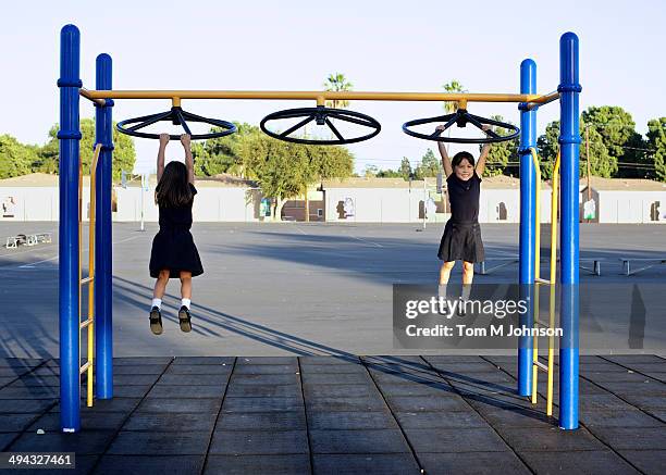 twin girls playing on playground - monkey bars fotografías e imágenes de stock