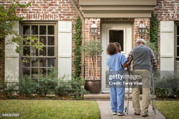 african american nurse helping patient use walker - texas house stock pictures, royalty-free photos & images