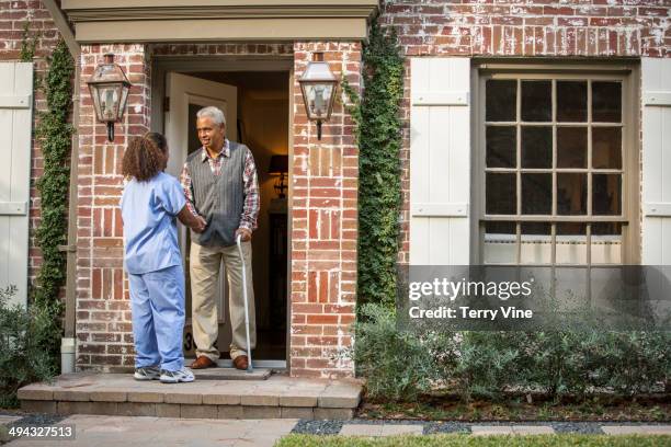 african american nurse helping patient use cane - old person with walking stick outside standing stock pictures, royalty-free photos & images