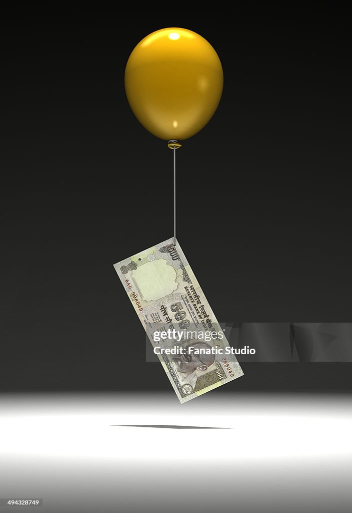 Indian five hundred Rupee note being lifted by balloon
