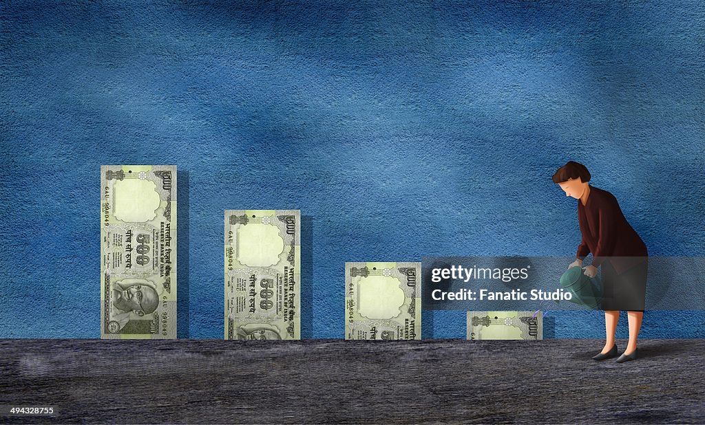 Businesswoman watering Indian currency notes