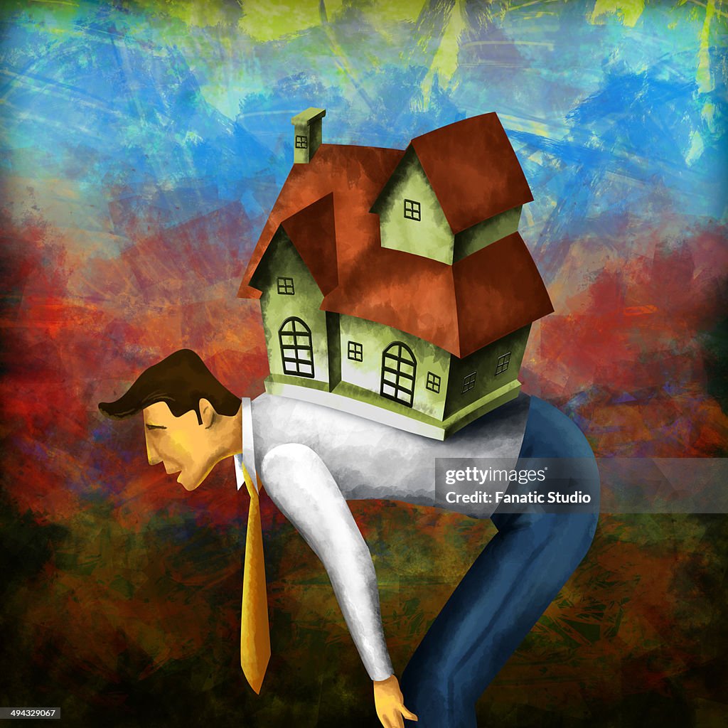 Side view of a businessman bending with model home on back depicting home loan burden