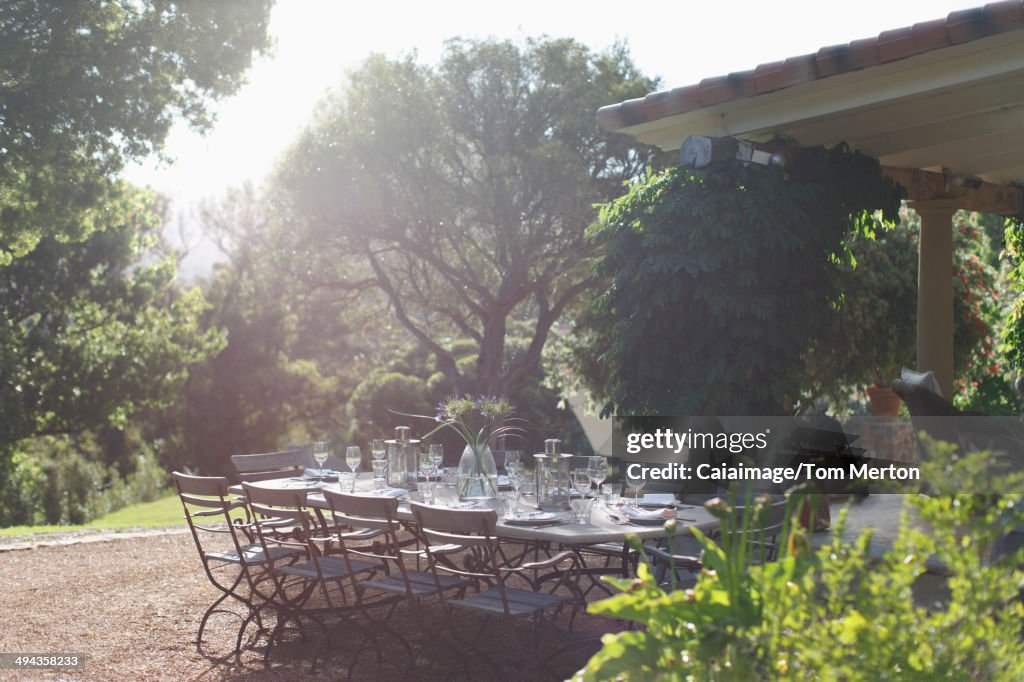 Place settings on sunny rural patio table