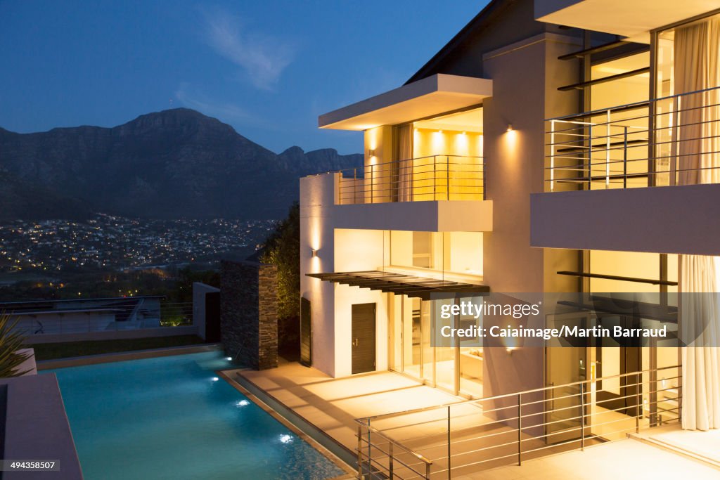 Modern house with swimming pool illuminated at night