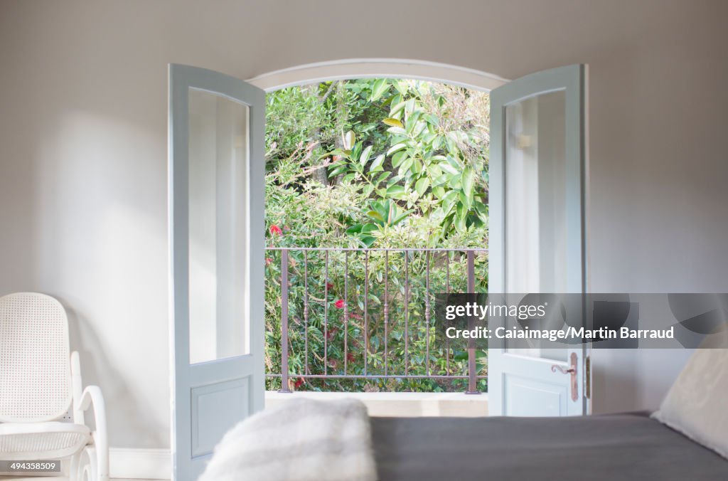French doors open to balcony in luxury bedroom
