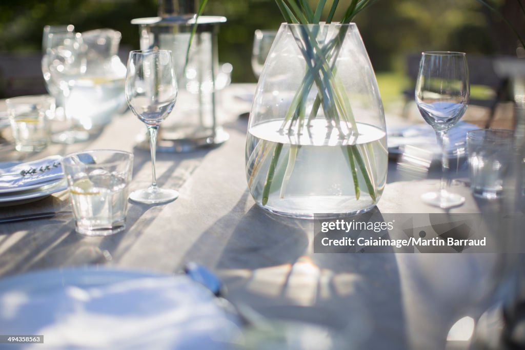 Configuración de jarrón y lugar en la mesa del patio soleado