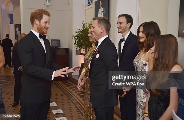 Prince Harry talks with Daniel Craig while attending The Cinema and Television Benevolent Fund's Royal Film Performance 2015 of the 24th James Bond...