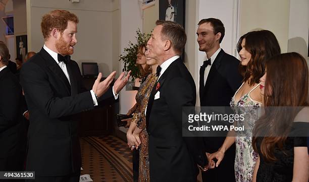 Prince Harry talks with Daniel Craig while attending The Cinema and Television Benevolent Fund's Royal Film Performance 2015 of the 24th James Bond...