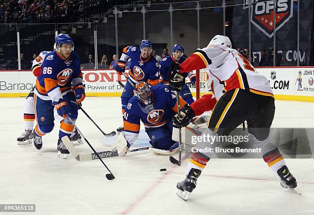 Nikolay Kulemin and Jaroslav Halak of the New York Islanders defend against David Jones of the Calgary Flames during the first period at the Barclays...