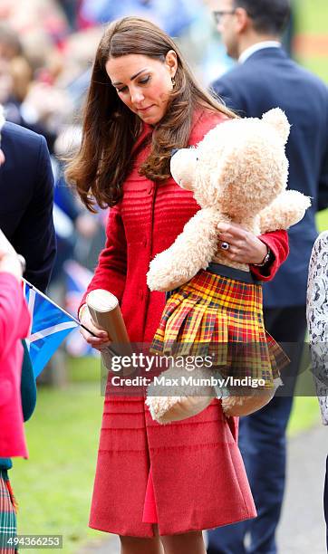 Catherine, Duchess of Cambridge receives a giant kilt wearing teddy from a young girl whilst on a walkabout in MacRosty Park on a day of engagements...