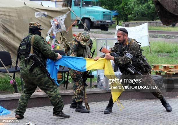 Pro-Russian fighters of Vostok battalion rip apart an Ukrainian flag outside a regional state building in the eastern Ukrainian city of Donetsk on...