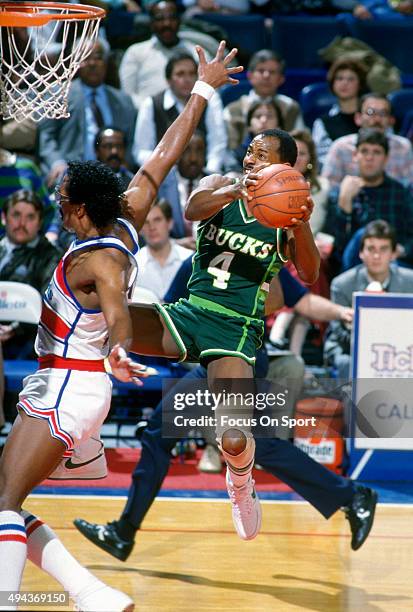 Sidney Moncrief of the Milwaukee Bucks goes up to shoot over Cliff Robinson of the Washington Bullets during an NBA basketball game circa 1986 at the...