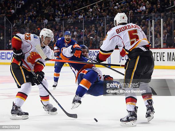 Mark Giordano of the Calgary Flames hits Frans Nielsen of the New York Islanders during the second period at the Barclays Center on October 26, 2015...