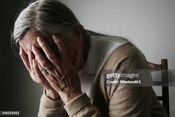 senior woman covering face with her hands - grief hands stock pictures, royalty-free photos & images