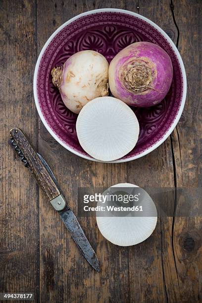 may turnip (brassica rapa ssp. rapa var. majalis) in a bowl and on wooden table - kohlrübe stock-fotos und bilder