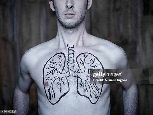 man taking breath with lung illustration on chest - emphysema stock-fotos und bilder