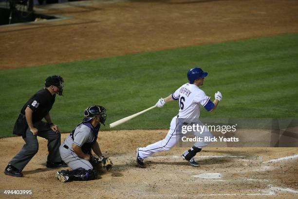 Lance Barksdale umpire and Michael McKenry of the Colorado Rockies look on as Donnie Murphy of the Texas Rangers hits in the fifth inning at Globe...