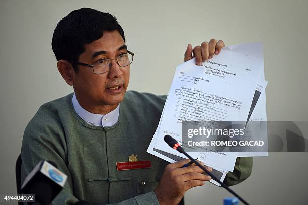 Myanmar's Union Election Commission director general U Tin Htun displays an election registration documents for overseas voters during a press...