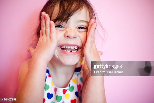 smiling girl with hands on face - vrouw spleetje tanden stockfoto's en -beelden