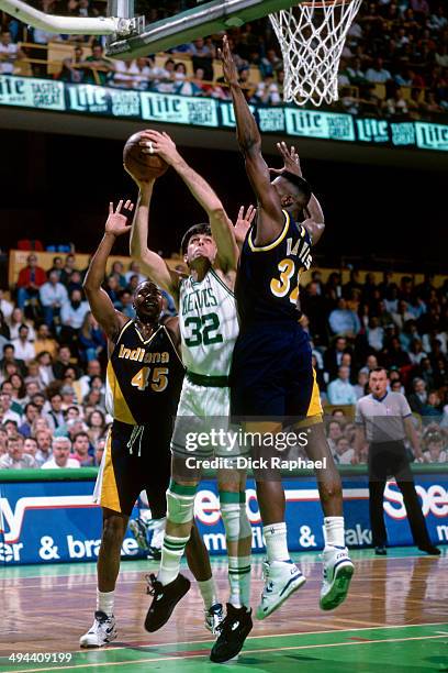 Kevin McHale of the Boston Celtics shoots against Chuck Person and Dale Davis of the Indiana Pacers during a game played in 1992 at the Boston Garden...