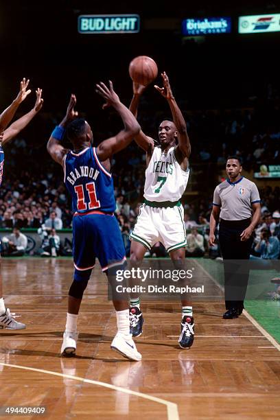 Dee Brown of the Boston Celtics passes the ball against Terrell Brandon of the Cleveland Cavaliers during a game played in 1992 at the Boston Garden...