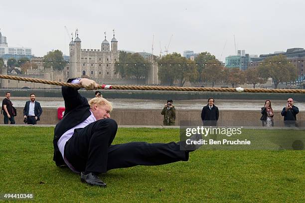 Mayor of London Boris Johnson slips over while competing in a tug of war during the launch of London Poppy Day on October 27, 2015 in London,...