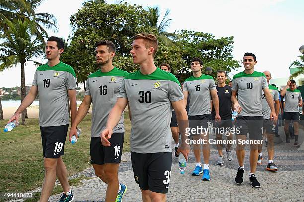 Ryan McGowan, James Holland and Oliver Bozanic of the Socceroos go for a beach walk at Praca dos Desejos on May 29, 2014 in Vitoria, Brazil. The...